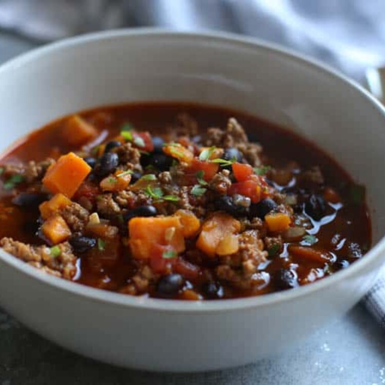 Turkey Chili with sweet potatoes nad black beans served in a white bowl.