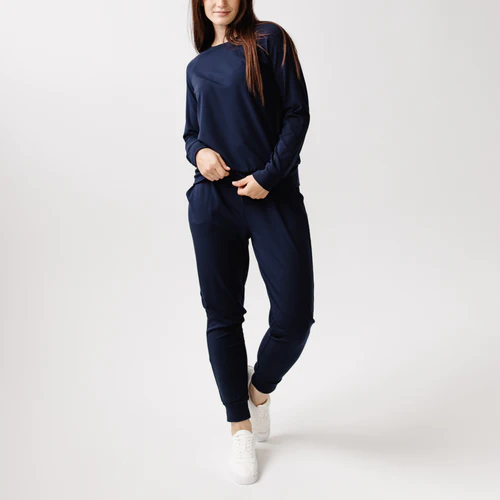 A woman wearing navy joggers and a navy top.