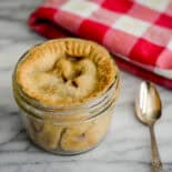 Pie in a mini mason jar ready to eat with a spoon next to it.