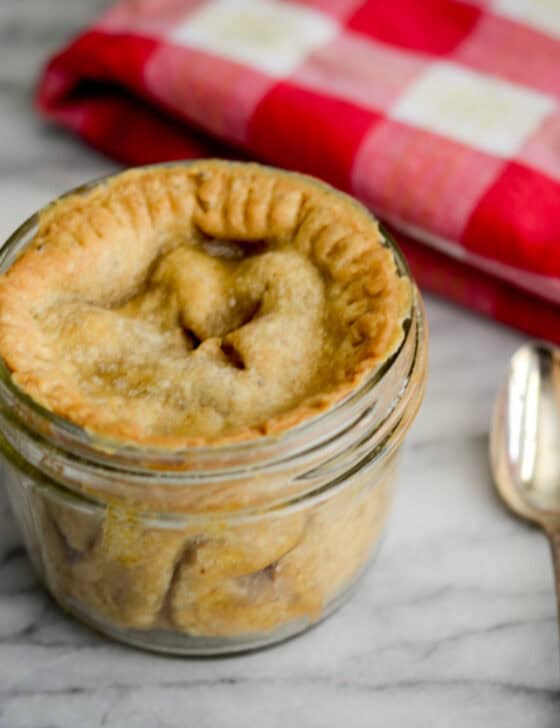 Pie in a mini mason jar ready to eat with a spoon next to it.