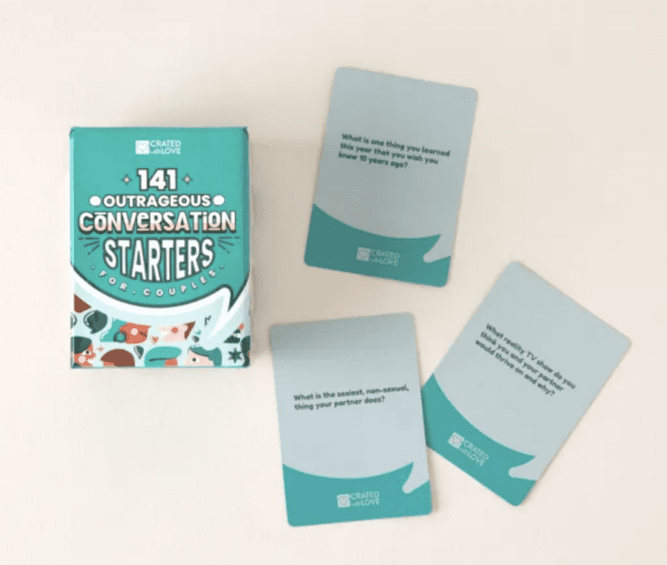A box of 141 Outrageous Conversation Starters with three single cards sitting around it.