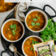 A stock pot and three bowls filled with cancer fighting vegetable soup.