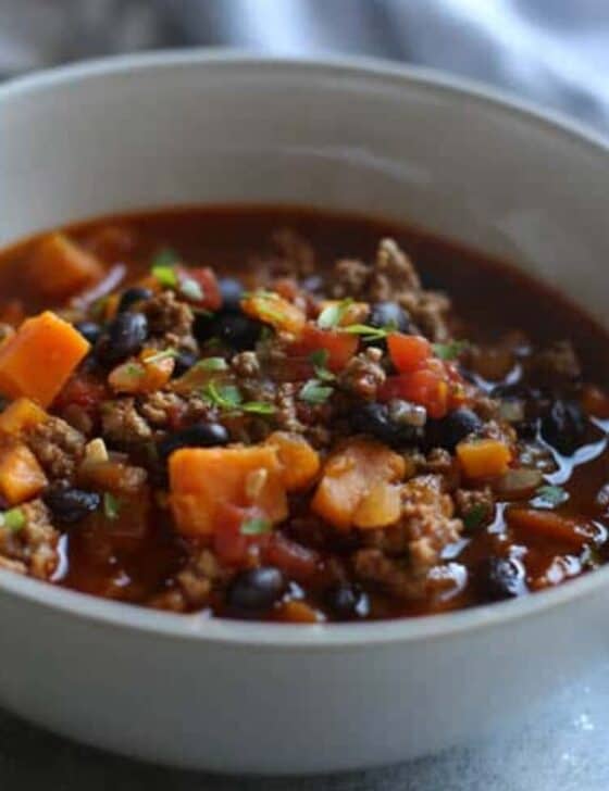 Turkey Chili with sweet potatoes nad black beans served in a white bowl.