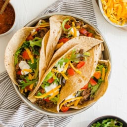 Shredded beef soft tacos on a plate.