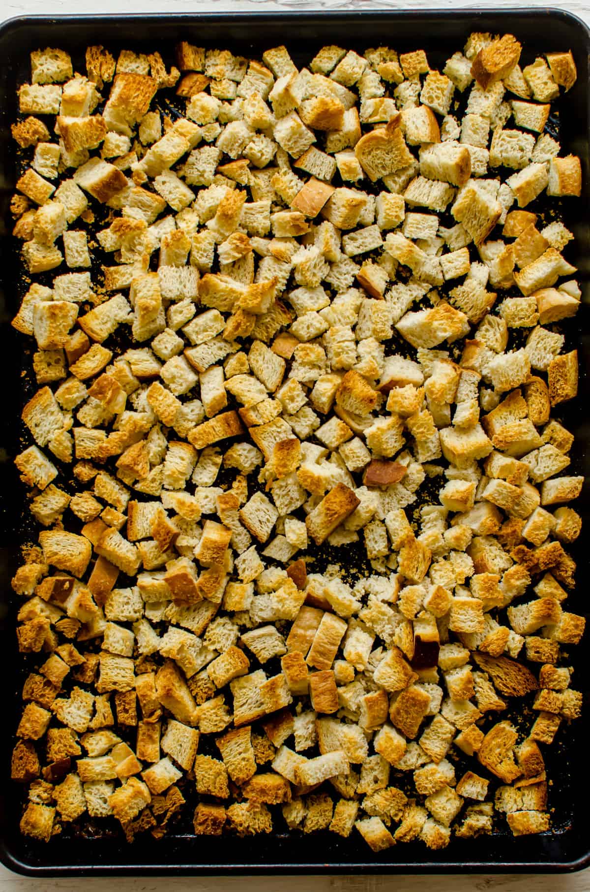 Toasted bread cubes on a sheet pan.