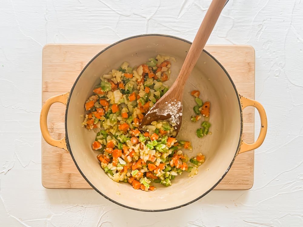 process shot of sauteed carrots, onions, celery, and garlic in a pot