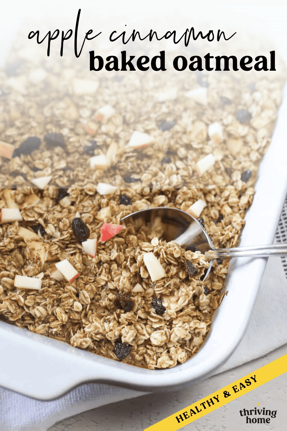 A spoon taking a serving of apple cinnamon baked oatmeal out of a white casserole dish.
