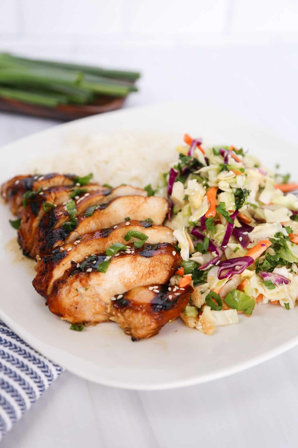 Marinated asian chicken sliced with asian slaw and rice.