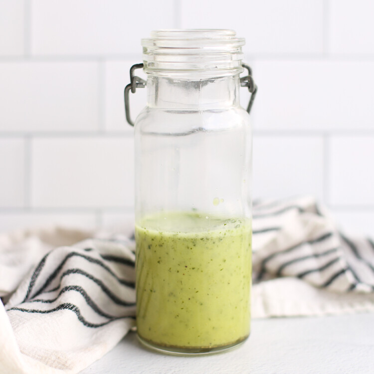 Homemade cilantro lime vinaigrette stored in a skinny glass jar.