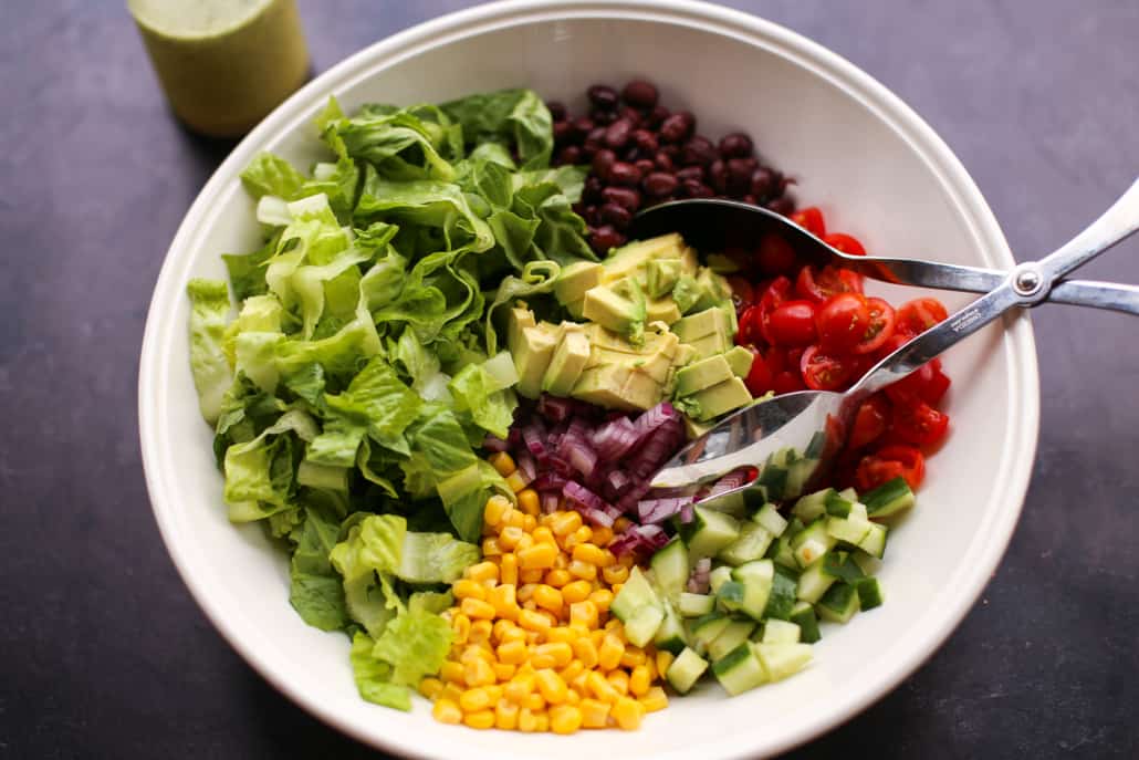 mexican chopped salad in a bowl with tongs