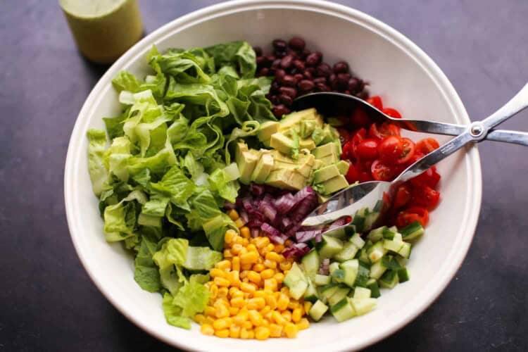 Mexican chopped salad served in a bowl with tongs.