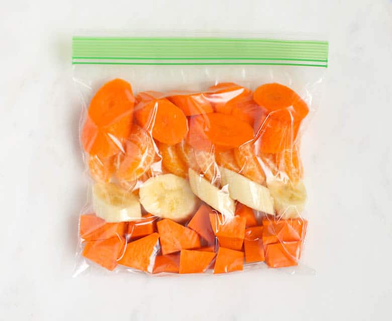 Orange smoothie ingredients prepped as a freezer smoothie pack in a ziplock bag. 