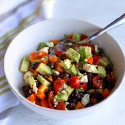 Bowl of beans, avocado, feta cheese, and more.