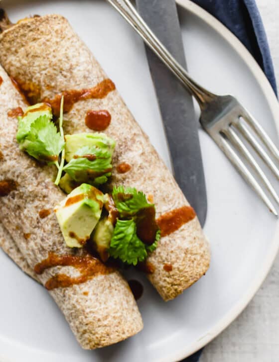 Beef taquitos on a plate with a fork and knife.