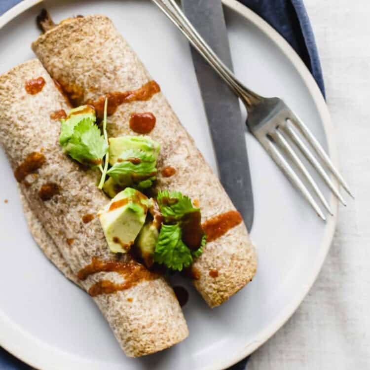 Beef taquitos on a plate with a fork and knife.