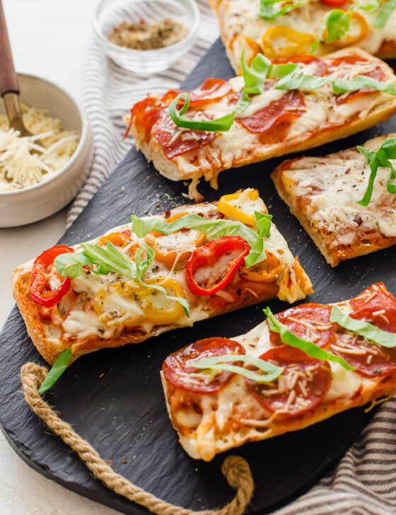 Pizza bread baked and sitting on a gray slate serving platter.