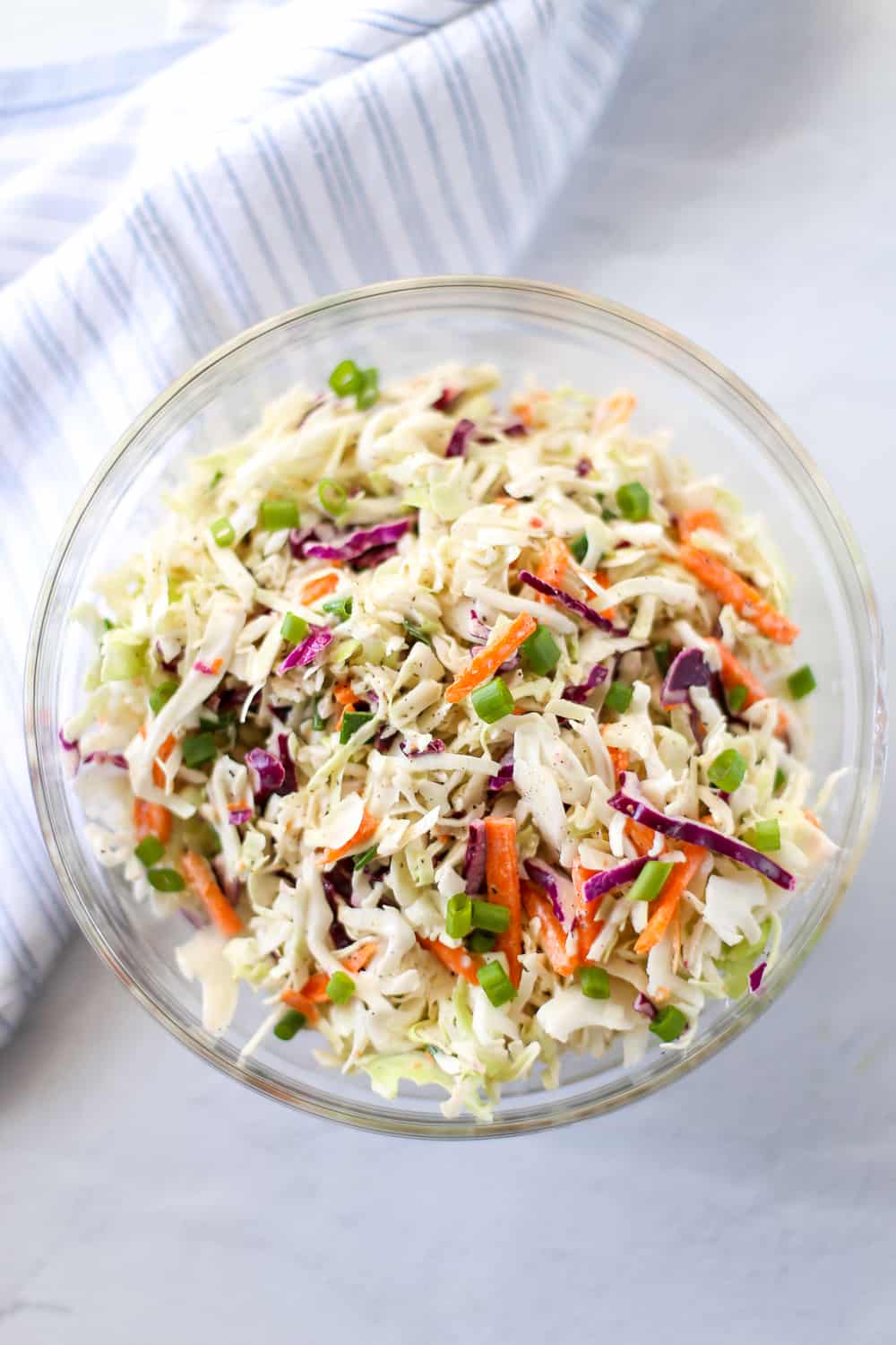 Overhead shot of coleslaw in a glass bowl