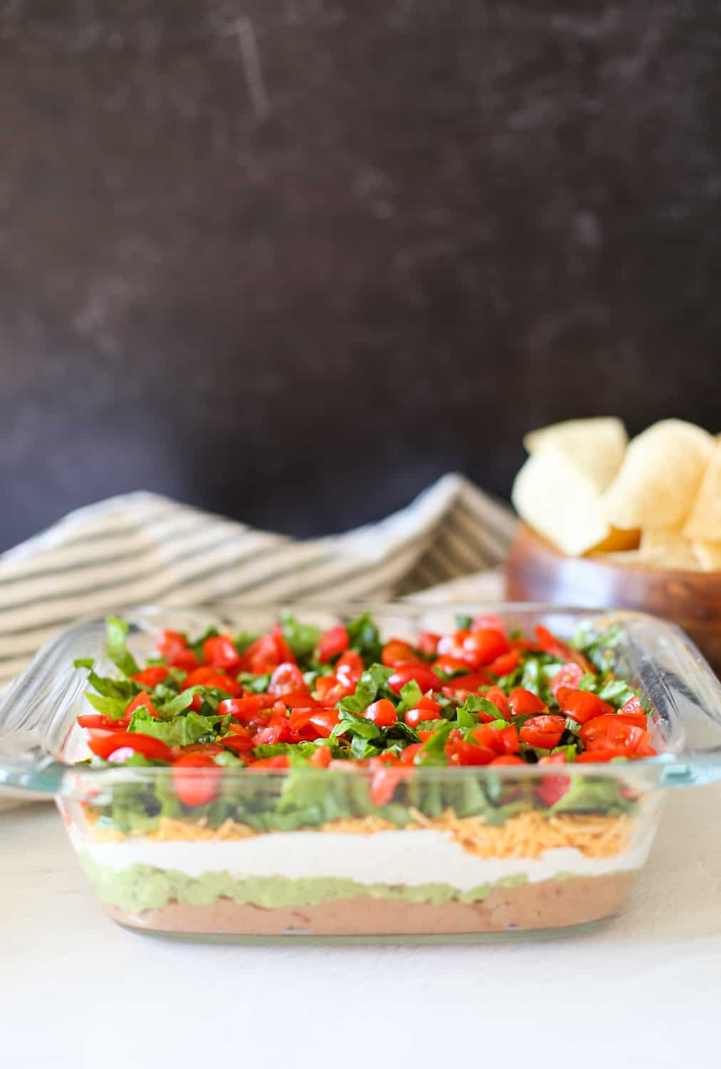 Layered Taco Dip in a glass dish.