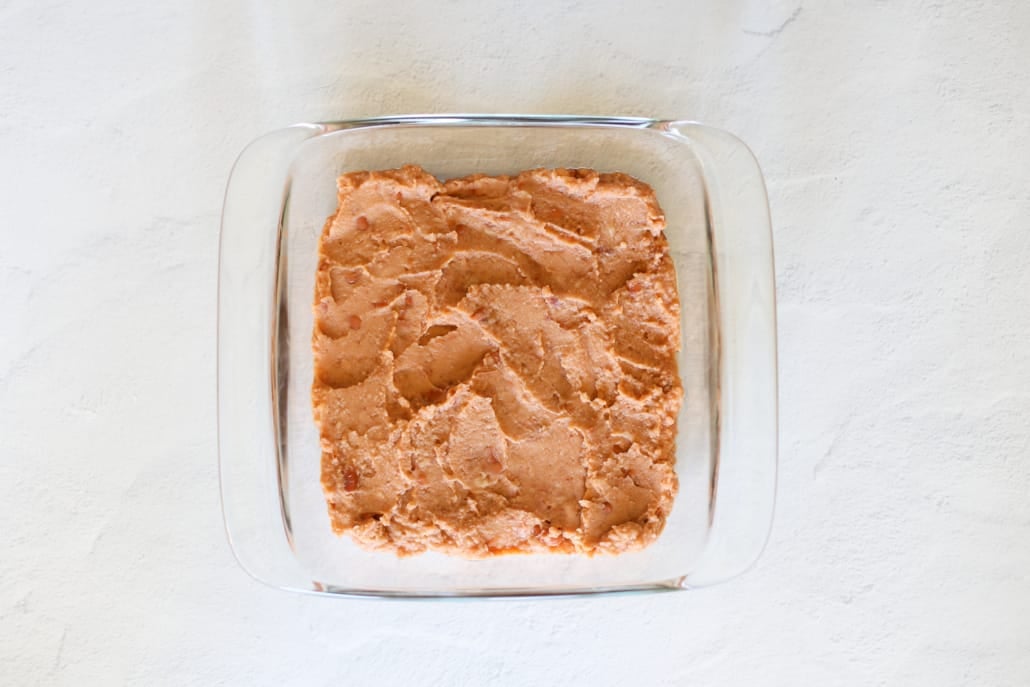 Overhead shot of refried beans in a glass 8x8 dish