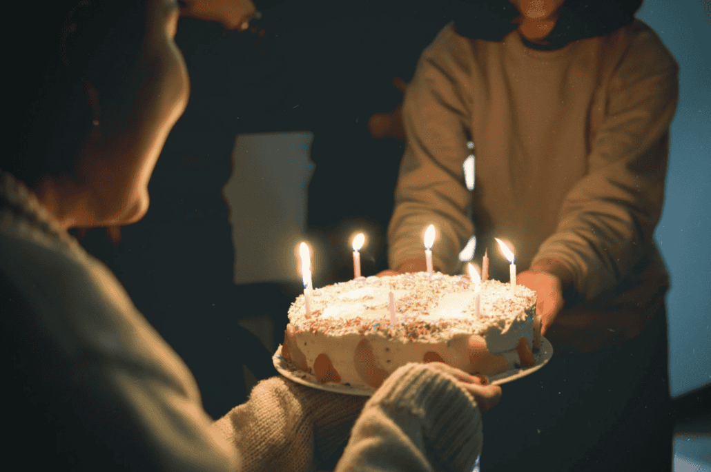 Birthday dinner: Cake being passed to someone 