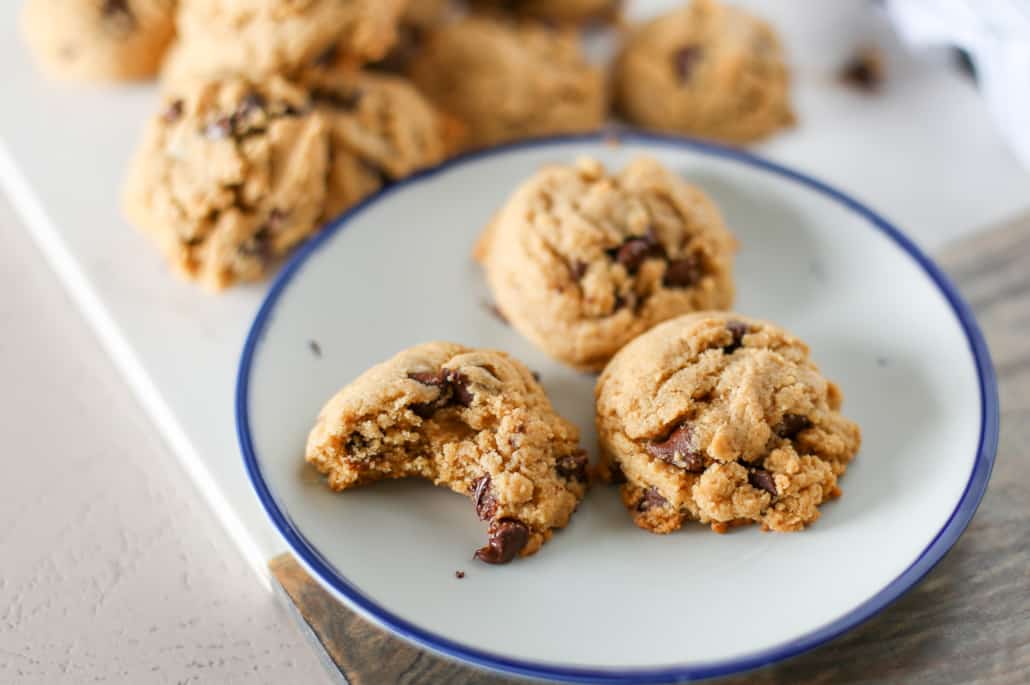 Whole wheat chocolate chip cookies, one with a bite taken out of it. 