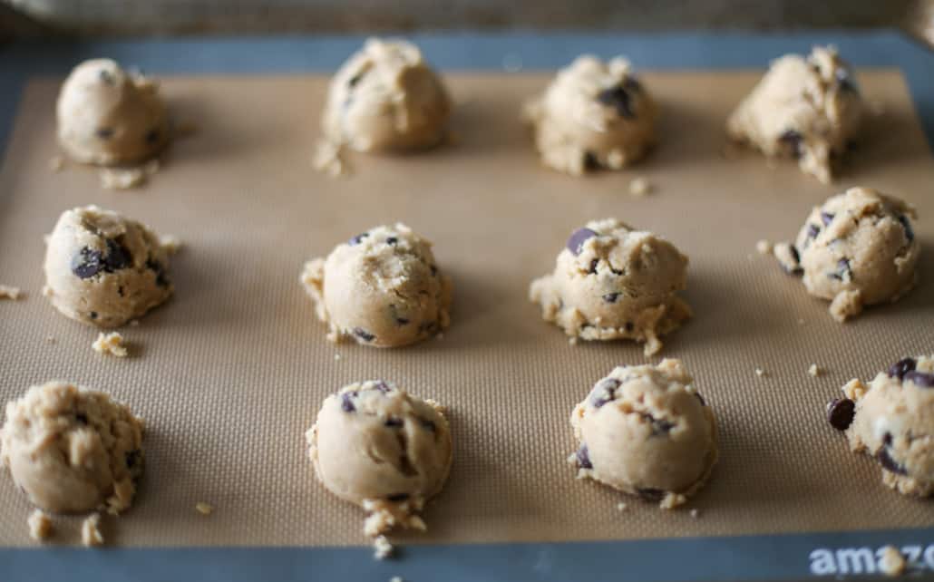 Whole wheat chocolate chip cookie dough scooped onto a silicone baking mat