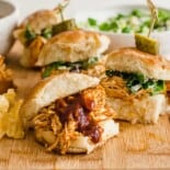 BBQ chicken sliders on a cutting board.
