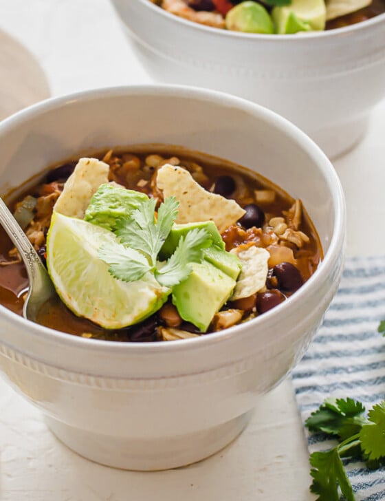 chicken taco soup in a white bowl with toppings
