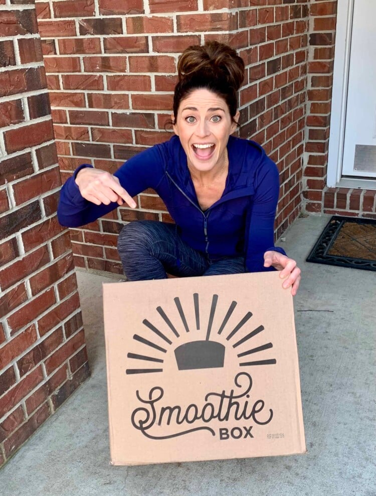 Rachel on her front porch excited and pointing to her Smoothie Box that was just delivered.