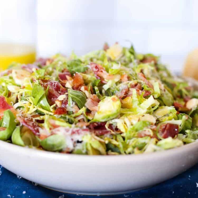 Shaved Brussels sprout salad in a white bowl.