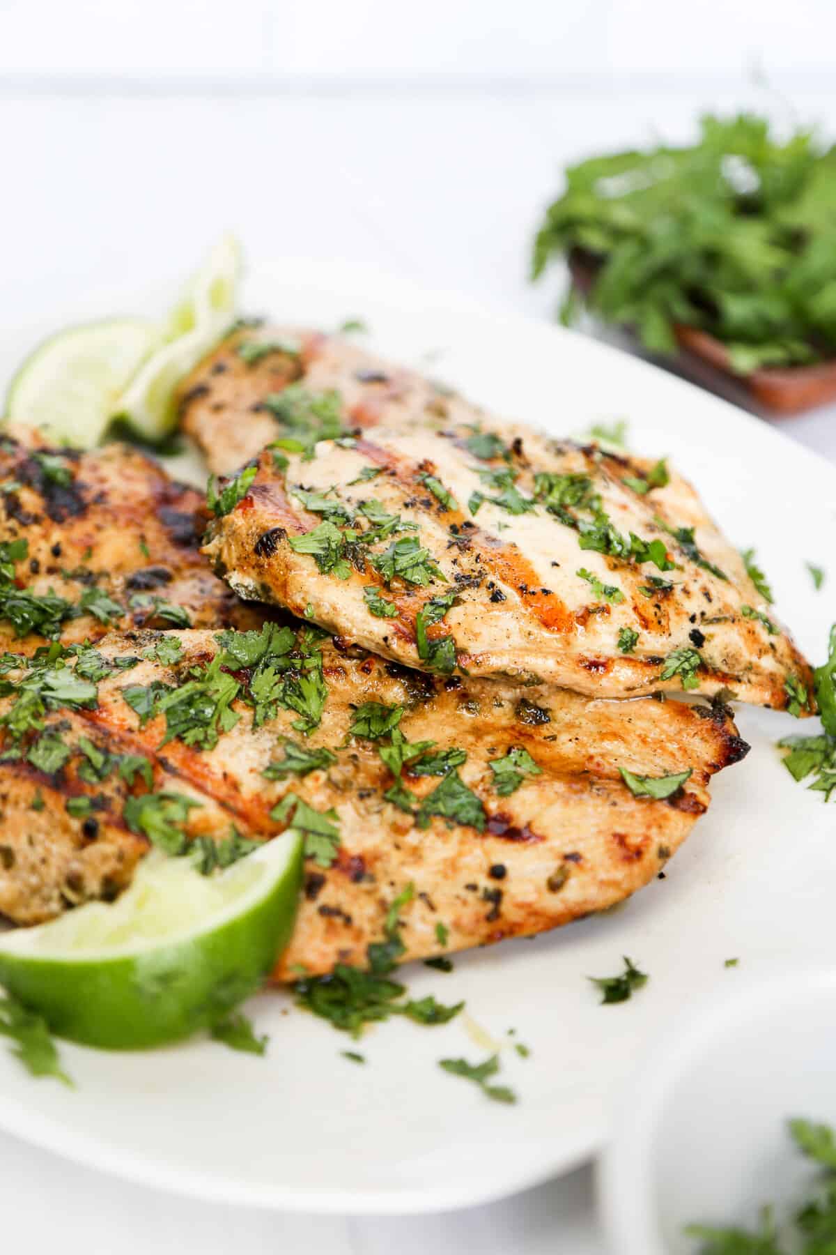 cilantro lime chicken grilled on a plate with limes