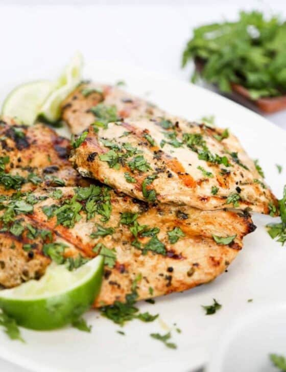 cilantro lime chicken grilled on a plate with limes