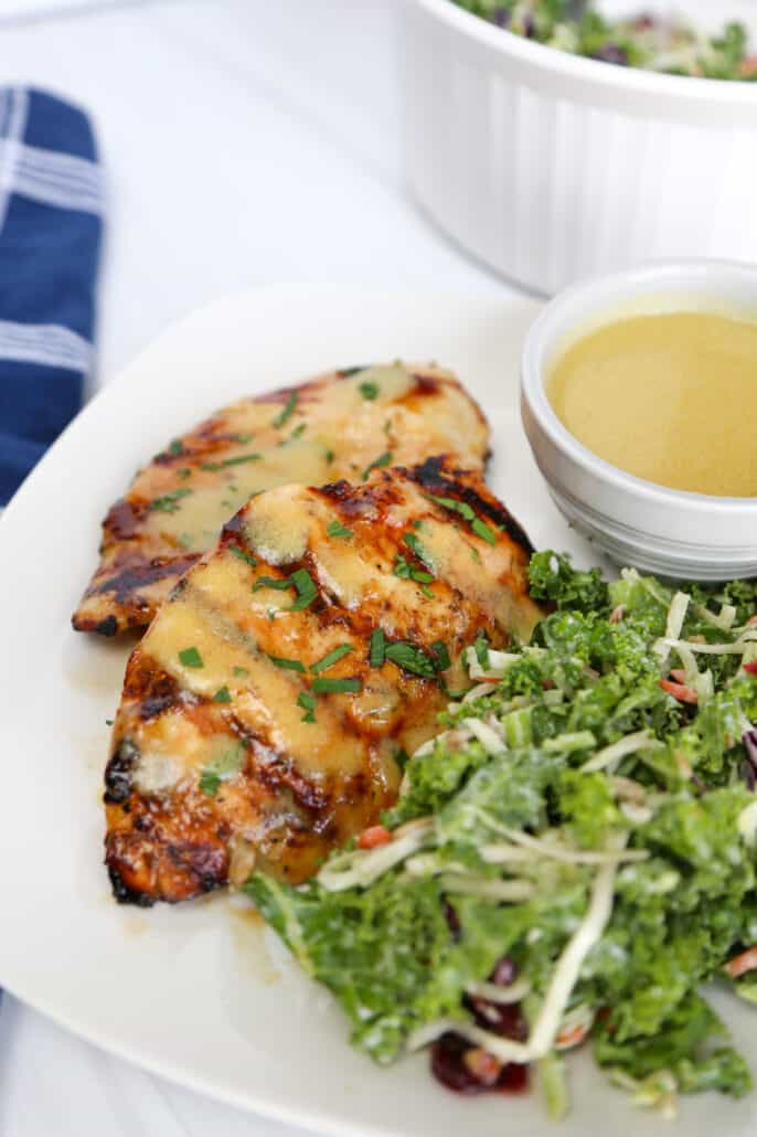 grilled honey mustard chicken on a plate with salad and sauce
