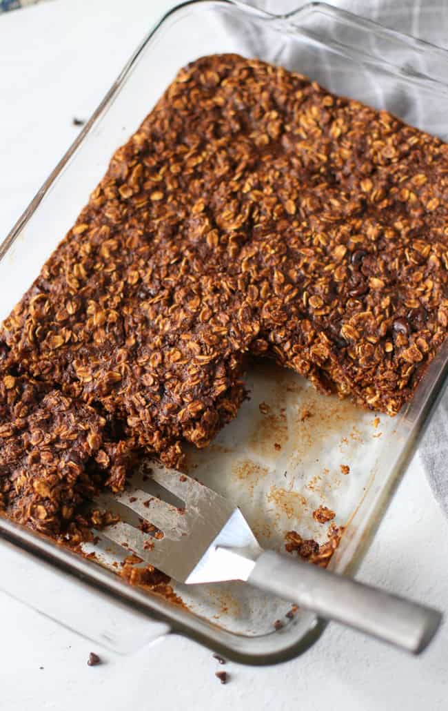 baked chocolate oatmeal in glass dish with a few pieces cut out of it