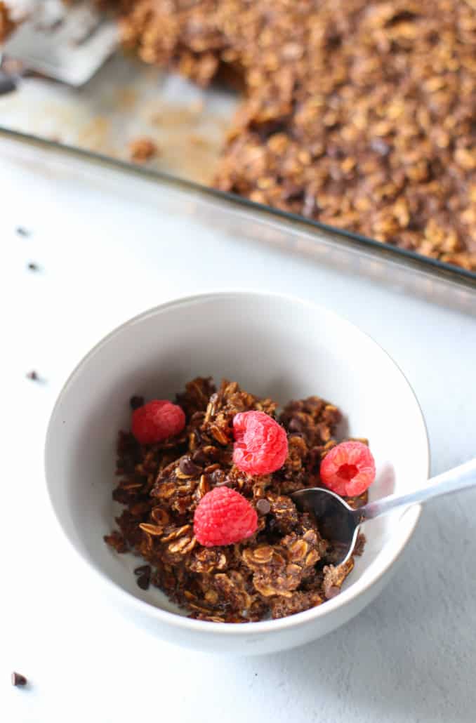 white bowl with chocolate baked oatmeal in it and raspberries on top