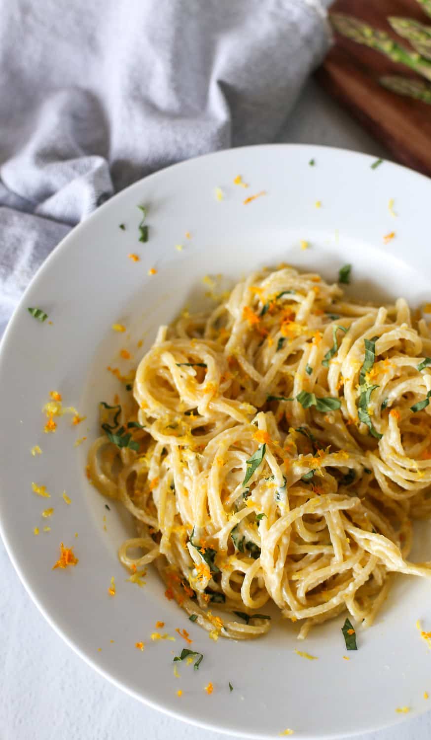 Creamy lemon pasta sauce over spaghetti in a white bowl.