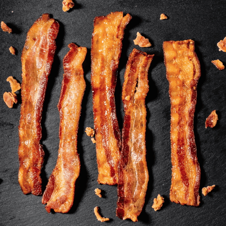 Cooked bacon on a granite background.