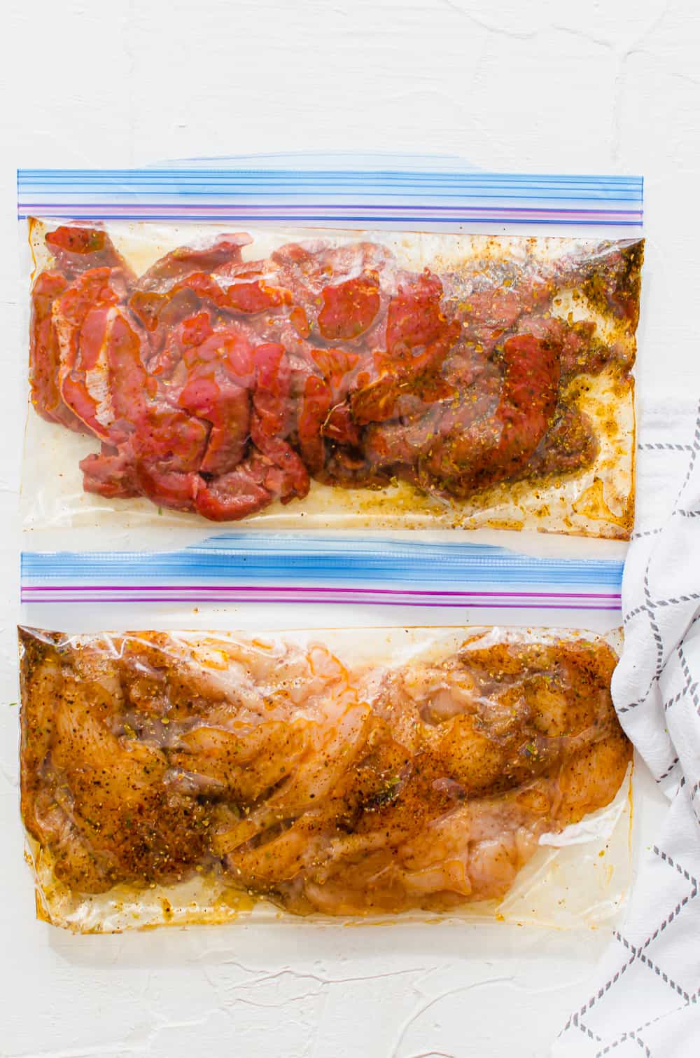 overhead shot of fajita steak and fajita chicken in freezer bags with marinade