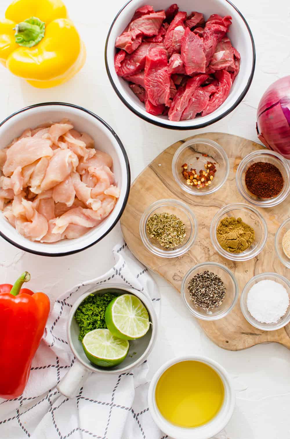 Ingredients for steak and chicken fajitas measured out in bowls.