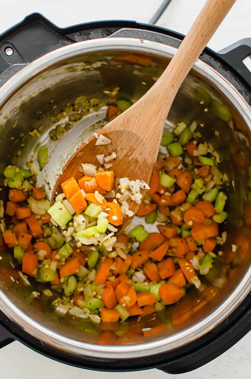 Carrots, celery, onion, and garlic sauteing in an Instant Pot.