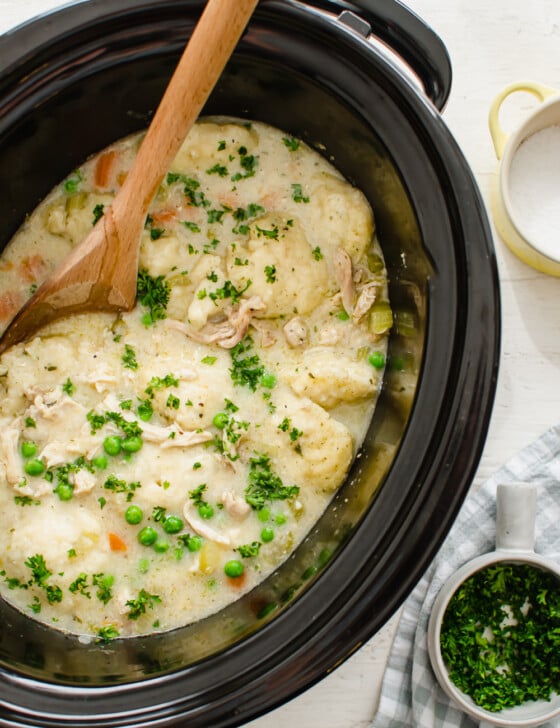Crock Pot chicken and dumplings ready to serve with fresh chopped parsley.