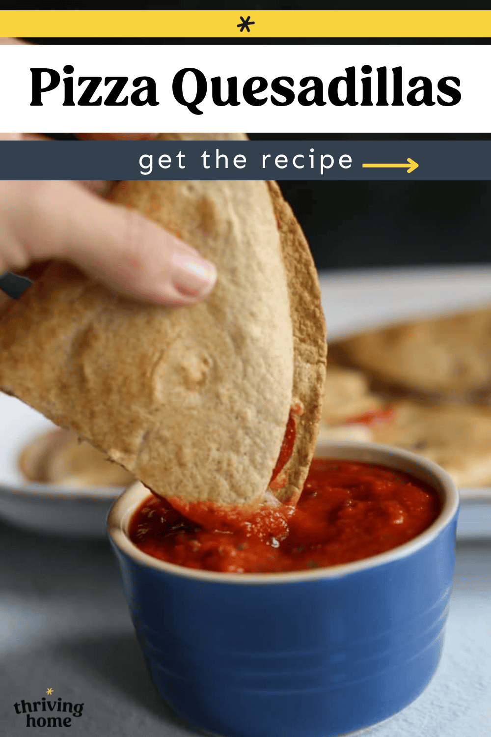 A pizza quesadilla being dipped into a ramekin of marinara sauce.