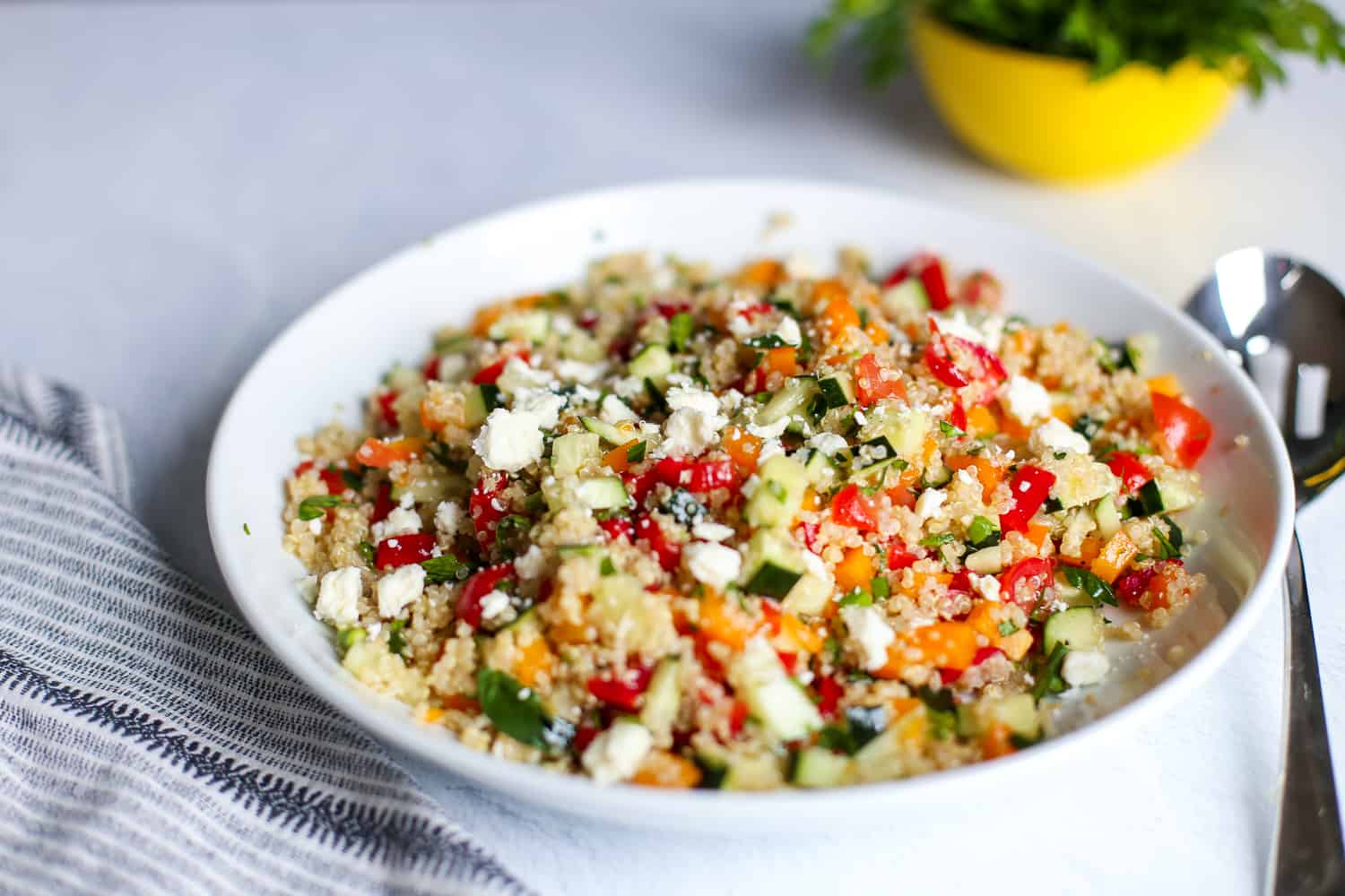 Quinoa tabbouleh salad in a white bowl.