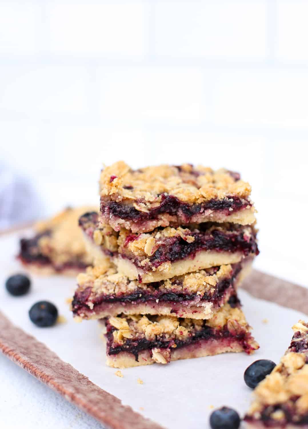 Blueberry Crumble Bars stacked on a wooden serving platter.
