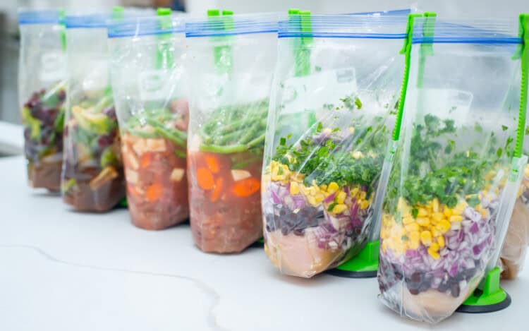 SIx Freezer Meals in Baggy Holders lined up on a counter.