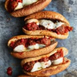 Meatball subs that have been under the broiler, side by side.