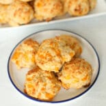 Cheddar biscuits on a white platter to serve.
