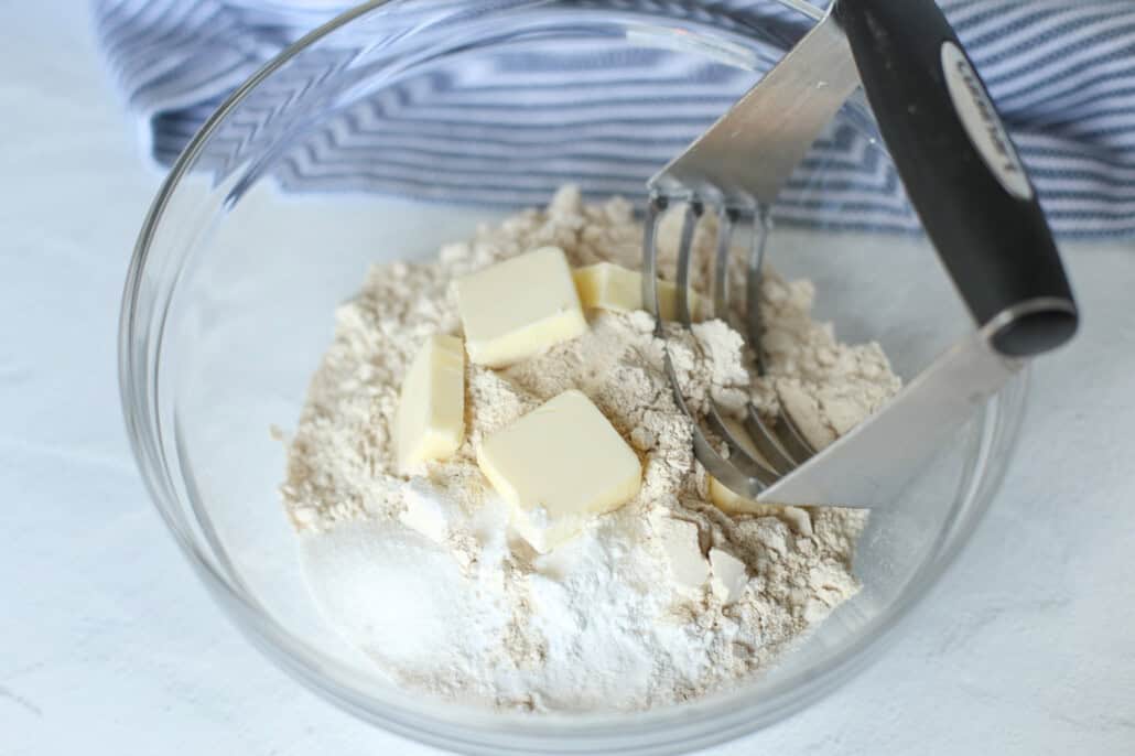 Cutting in the butter to cheddar biscuit mix. 