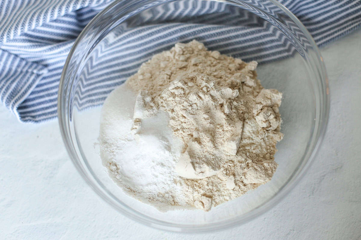 Dry ingredients for gluten-free pumpkin muffins in a glass bowl.