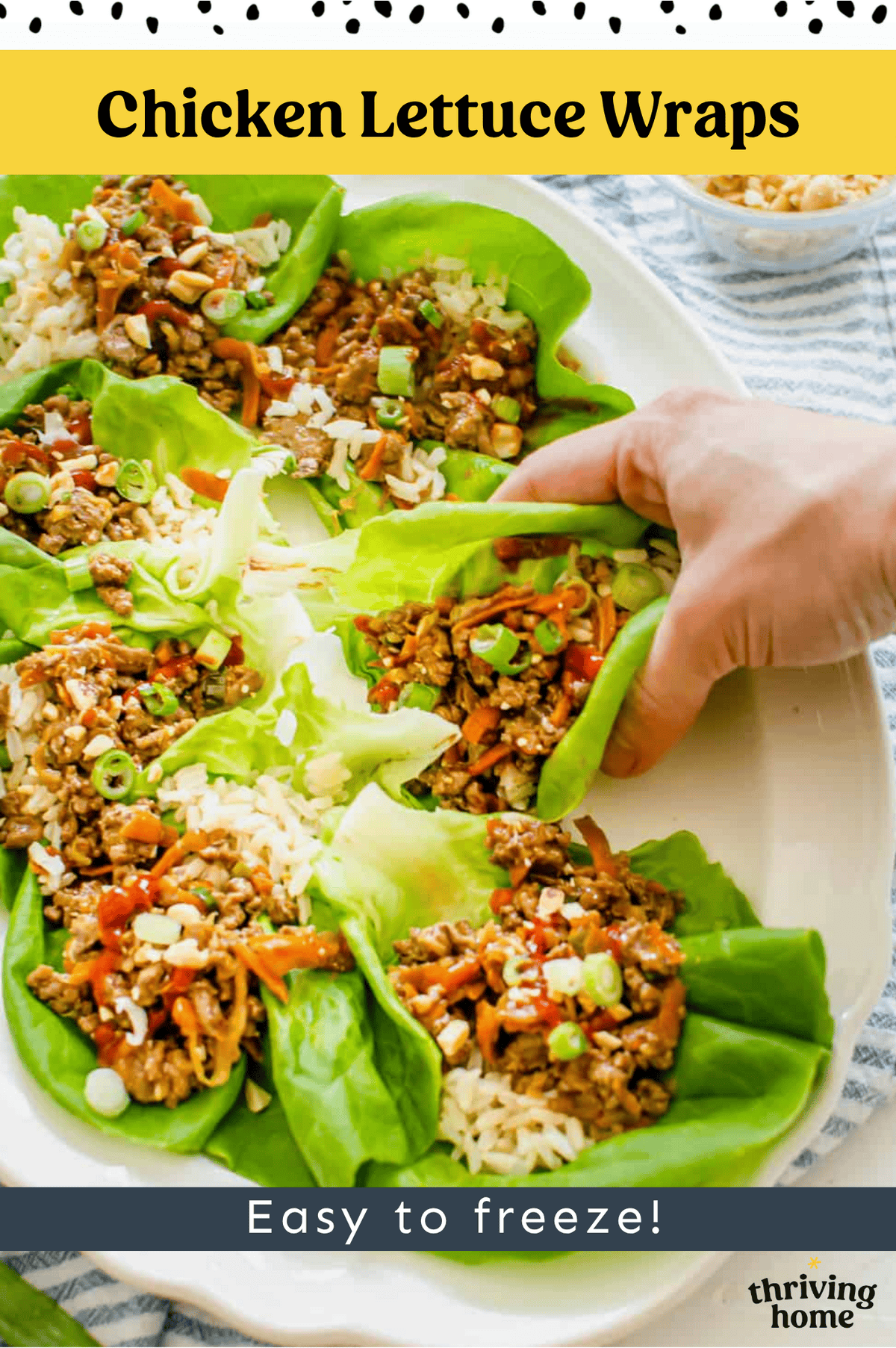 A platter of Asian chicken lettuce wraps with a hand picking one up.